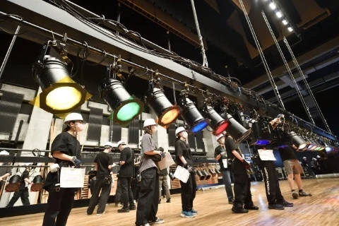 照明機材をバトンに吊るしていく、“吊り込み”の作業中